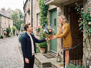 Un hombre joven le regala un ramo de flores a la mujer que pretende